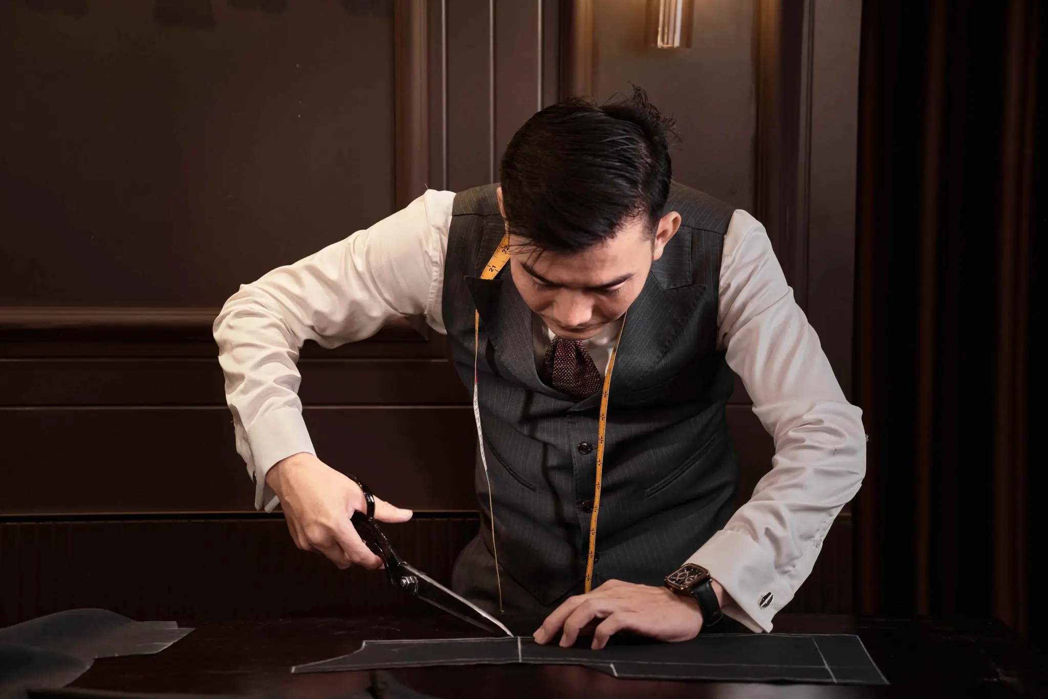 Thợ may cắt rập vest thủ công trên bàn làm việc
